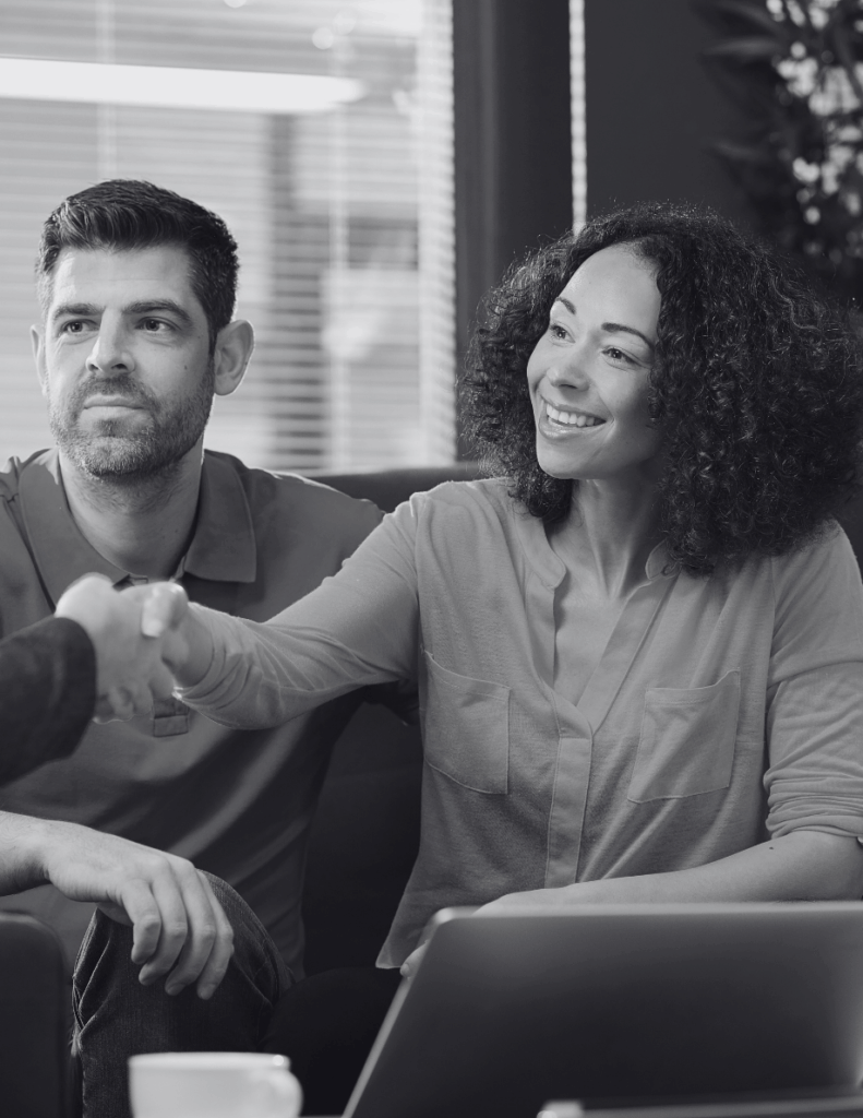 Smiling Skilled Worker visa holder couple discussing UK mortgage with adviser