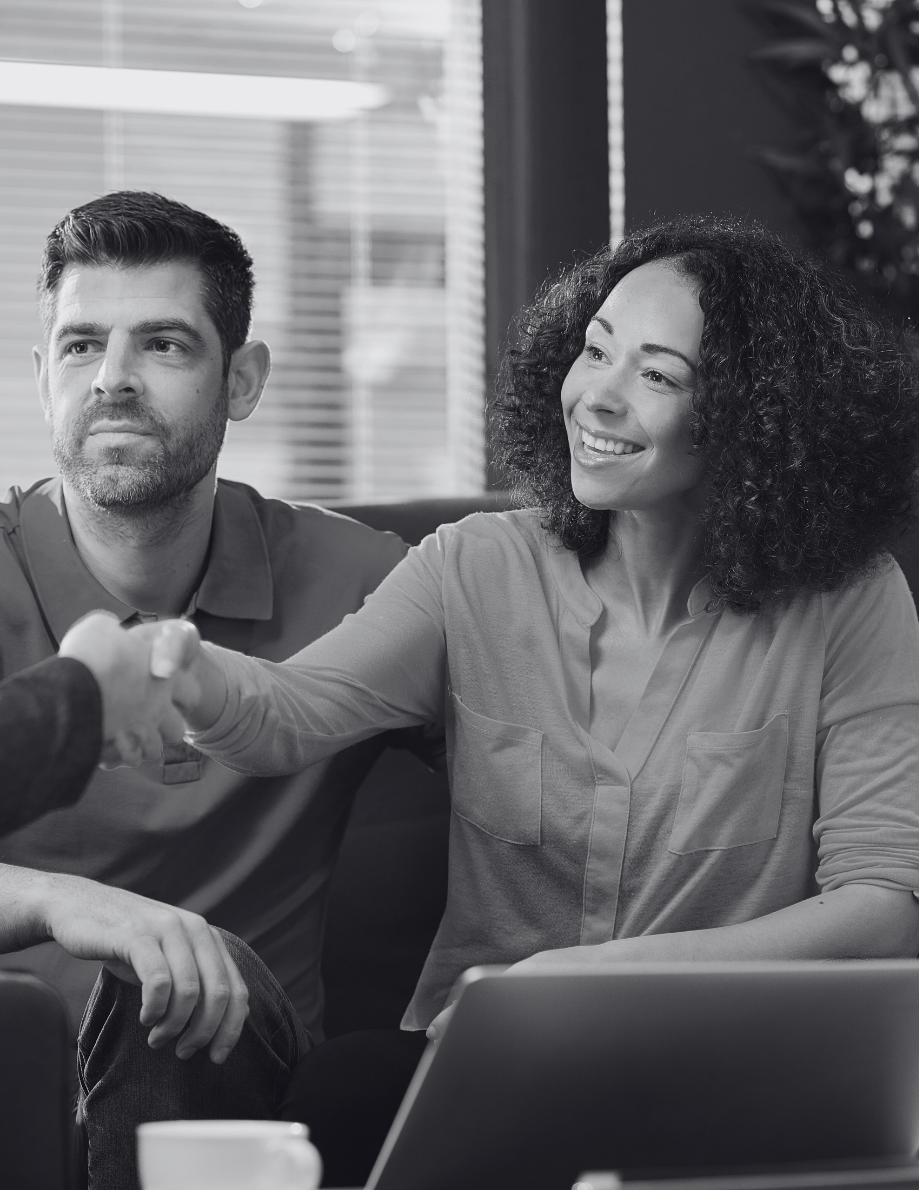 Smiling Skilled Worker visa holder couple discussing UK mortgage with adviser
